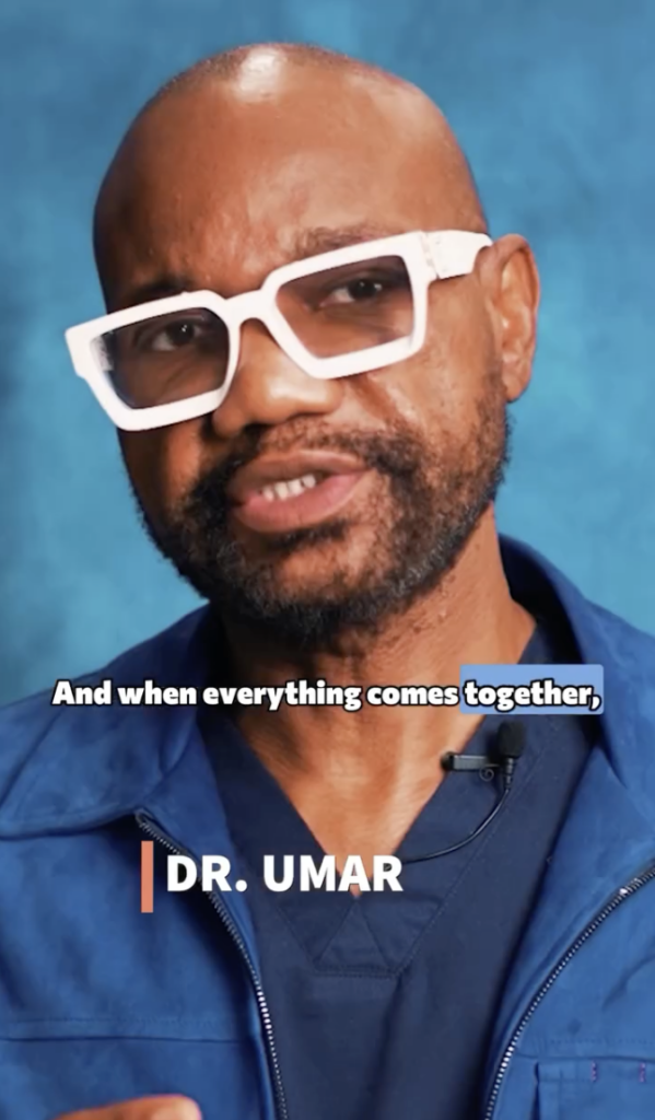 Dr. Sanusi Umar wearing white glasses and a blue jacket against a blue background.