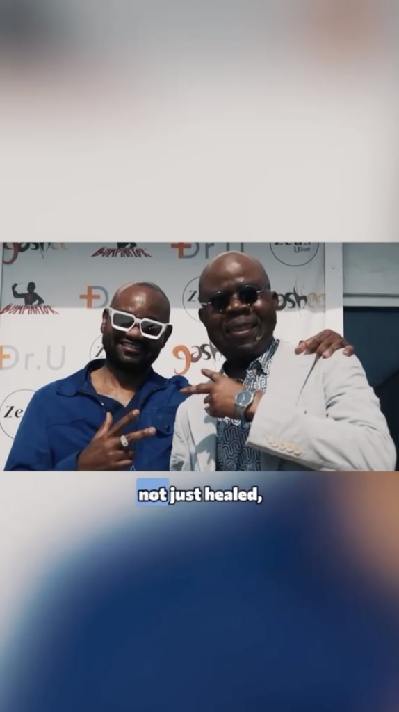 Dr. Sanusi Umar in white glasses and Festus in dark sunglasses posing together in front of a Dr. U and Bumpinator backdrop.